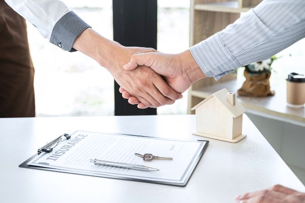 Locales en renta, dos personas estrechando sus manos después de firmar un contrato de renta de propiedades. 