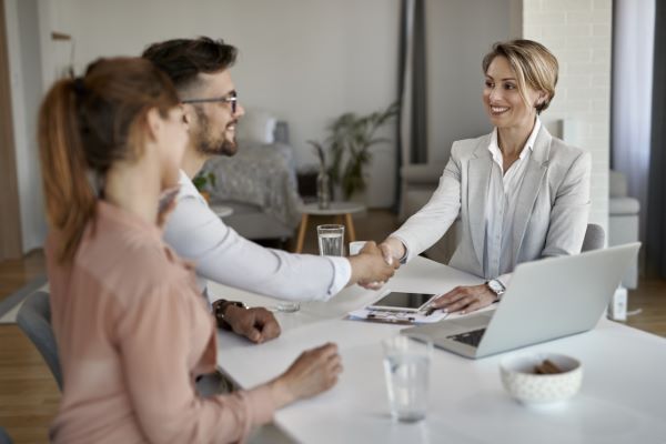 Una agente inmobiliaria cerrando un trato con una pareja.