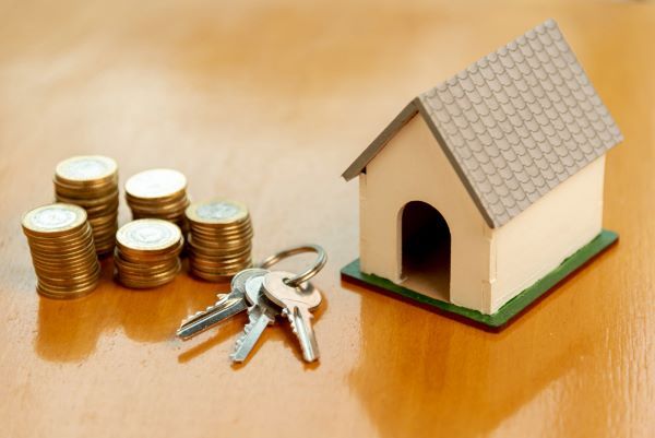 Casas en renta en Querétaro; una casa de juguete, unas llaves y un dinero