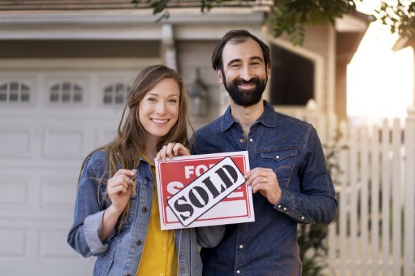 Casas en venta en Querétaro; dos personas sonriendo con un letrero de vendido
