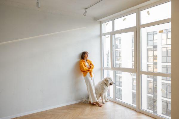 Departamentos en renta en Querétaro; Mujer y perro mirando hacia la ventana.