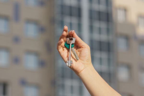 Departamentos en venta en Querétaro; imagen de la mano y brazo de una persona sosnteniendo un juego de llaves de un departamento que será puesto en venta.