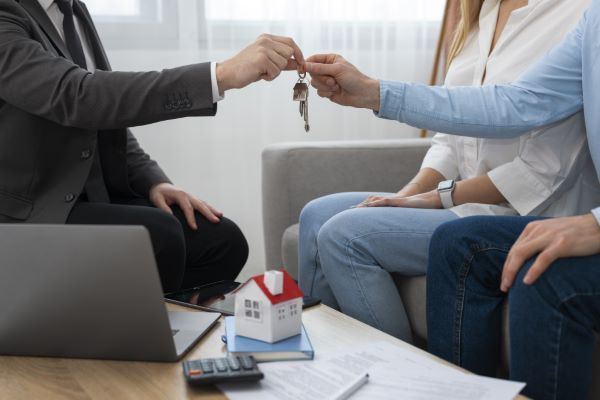 Departamentos en venta en queretaro; agente inmobiliario entregando unas llaves a una pareja