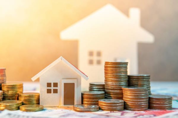 Casas en venta en Metepec; Una casa de color blanco con una monedas doradas a los lados.