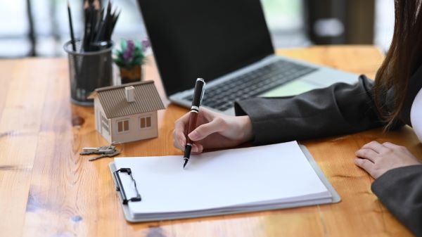 Casas en renta en Metepec; Agente de bienes raíces firmando un contrato.