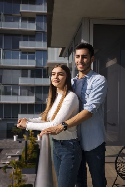 Casas en renta en Querétaro; Pareja feliz observando su nuevo hogar desde el balcón