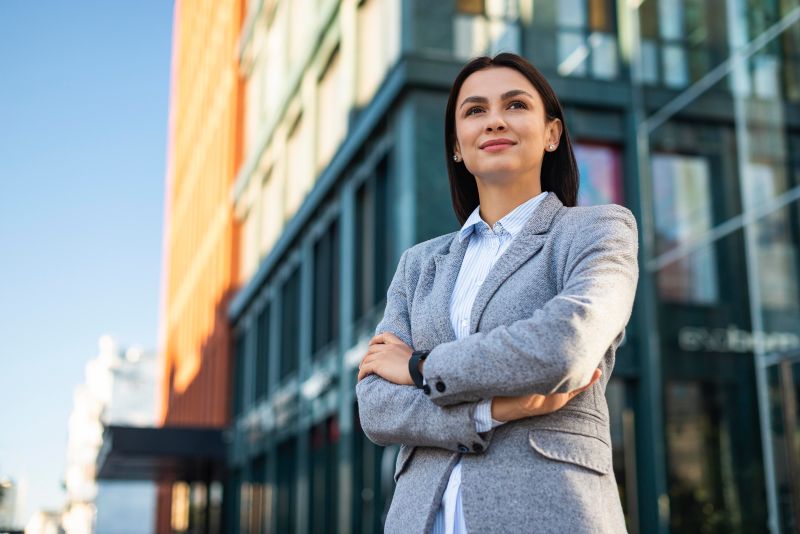 Ángulo bajo de mujer de negocios en la calle frente a su emprendimiento