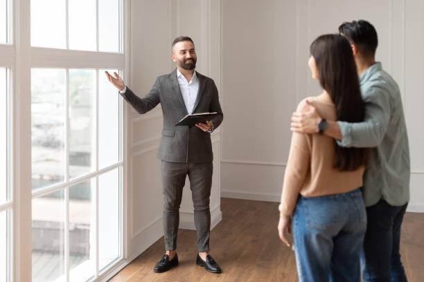 Agencia inmobiliaria;Una persona levantando la mano y señalando la ventana