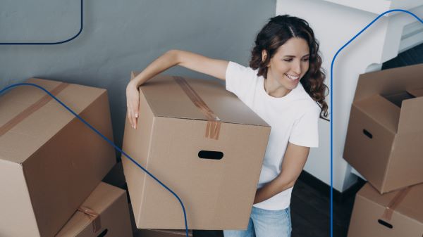 Casas en renta; imagen de una mujer con varias cajas de mudanza siendo feliz tras haber tomado la decisión de rentar una casa.
