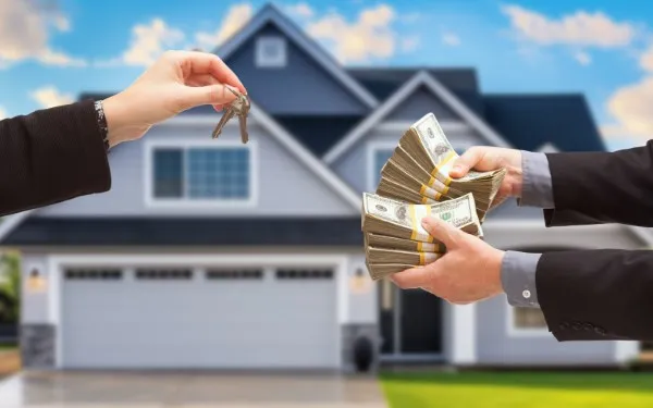 Foto de mano entregando llaves y manos entregando dinero en una transacción de compra de casa.