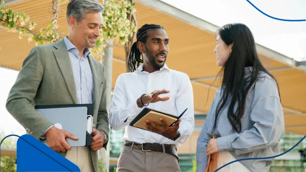 Foto de dos hombres y una mujer que son asesores inmobiliarios trabajando en la planeación de su siguiente proyecto