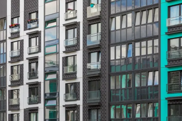 Fotografía del exterior de departamentos nuevos en color gris de una zona residencial